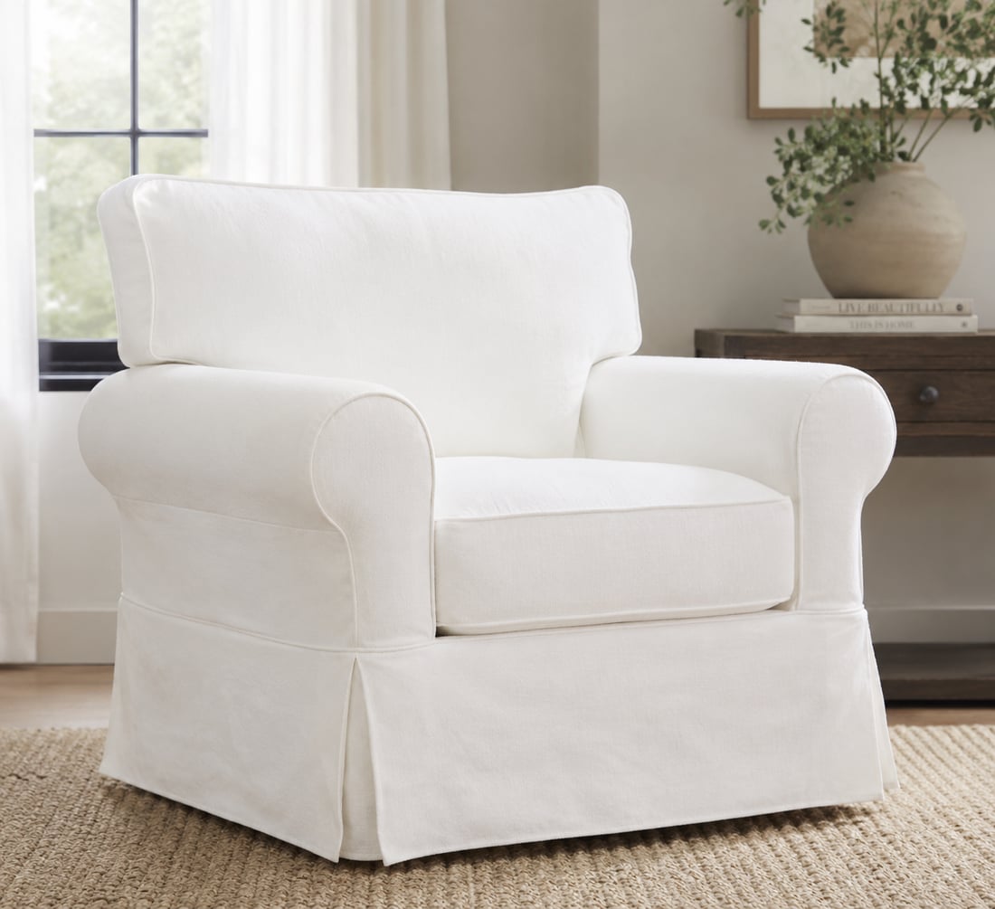 A plush white slipcovered accent chair in a bright, styled room